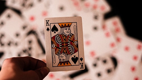 Kartu King of Spades diadakan di atas setumpuk kartu