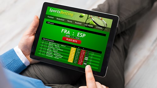 Man using sports betting app on tablet computer