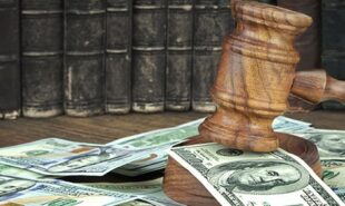 Judges Gavel And Scattered Money Heap On Wooden Table Close Up