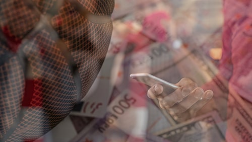 Man holding phone against a background of a basketball and money