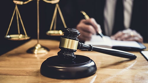 Male lawyer or judge working with contract papers, Law book and wooden gavel on table in courtroom