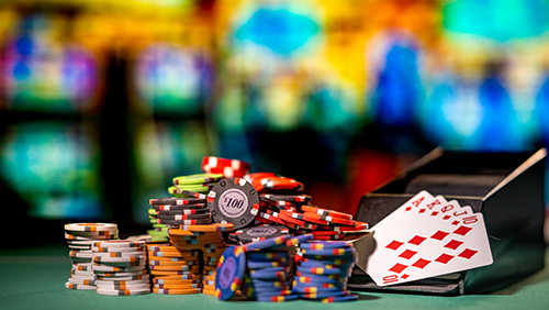 Stacks of poker chips and cards with a blurry casino background. Concept of gambling