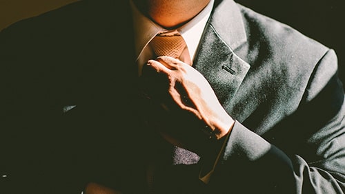 Business man adjusting his necktie