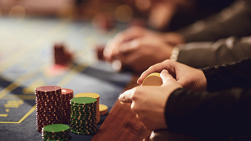 People playing casino poker at a table in a casino.