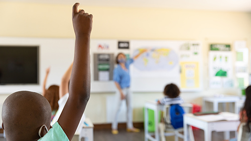 Teacher teaching children at school classroom