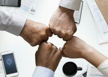 Four different hands bumping fists. Concept of partnerships
