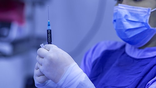 A medical person holding an injection/vaccine