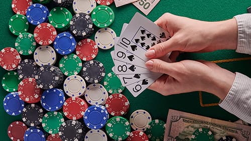 A dealer shuffling poker cards. poker table a lot of money and chips