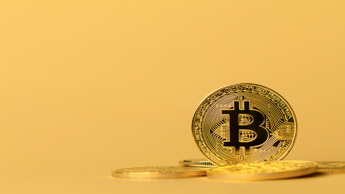 gold-bitcoin-cryptocurrency-coins-on-yellow