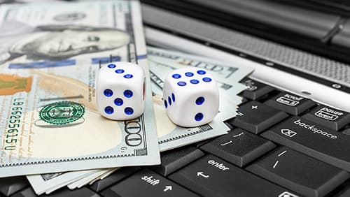 Dice with money on the laptop keyboard