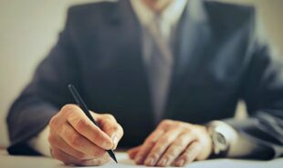 Zoomed photo of a male employee writing on a piece of paper