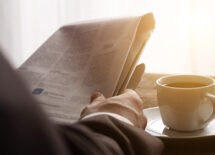 Businessman reading newspaper with coffee in the morning
