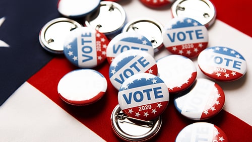 "Vote" pins on top of the USA flag
