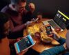 Excited fans in bar with beer and mobile app for betting, score on their devices.