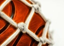 Close up of basketball in net.