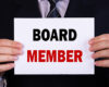 businessman holding board member sign