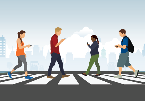 A group of people crossing the road using mobile phones