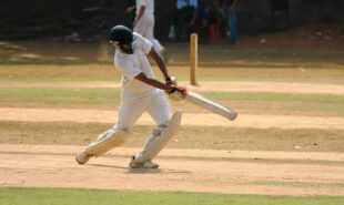 A cricket player hitting the ball