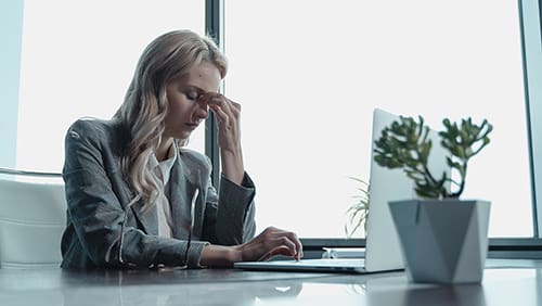 Woman in Black Leather Jacket Sitting at the Table looking stressed