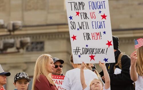 Protesters at \'Stop the Steal\' rally holding signs for honest election and in support of Donald Trump