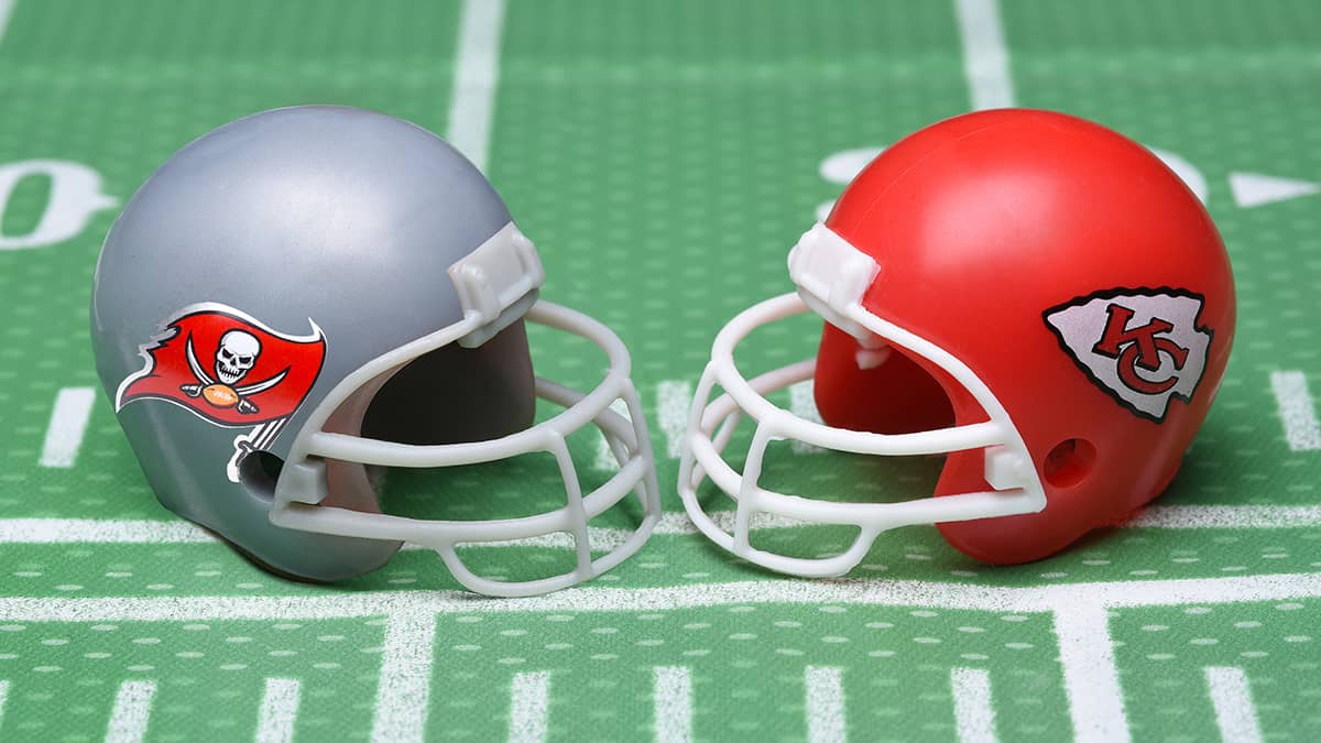 Helmets for the Tampa Bay Buccaneers, and Kansas City Chiefs, opponents in Super Bowl LV. on a green football field background