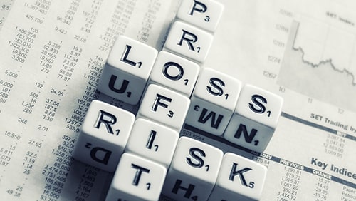 Different letter tiles spelling "Profit" , "Loss" and "Risk"