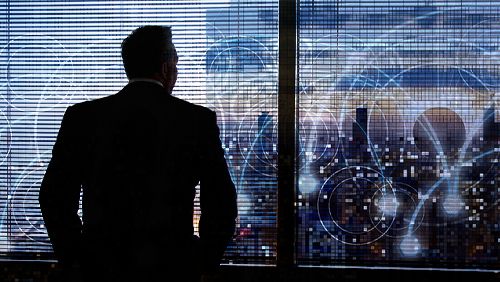 businessman looking over evening skyline with data concept