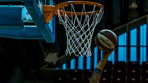 Man holding white and blackspalding basketball near brown and white basketball hoop