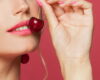 A woman with make up eating cherry
