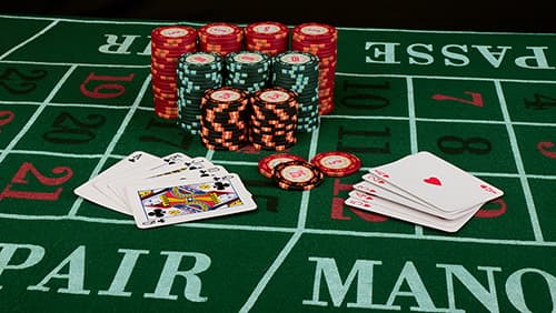 Casino card game showing chips on green cloth background