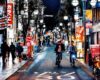 People riding the bike and walking on the side walk, night life, Japan city at night