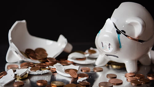 Broken piggy bank with coins scattered