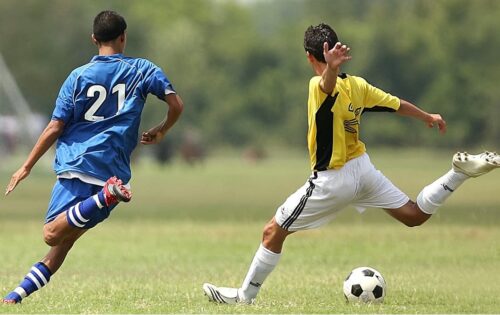 Two player in the soccer field kicking the ball